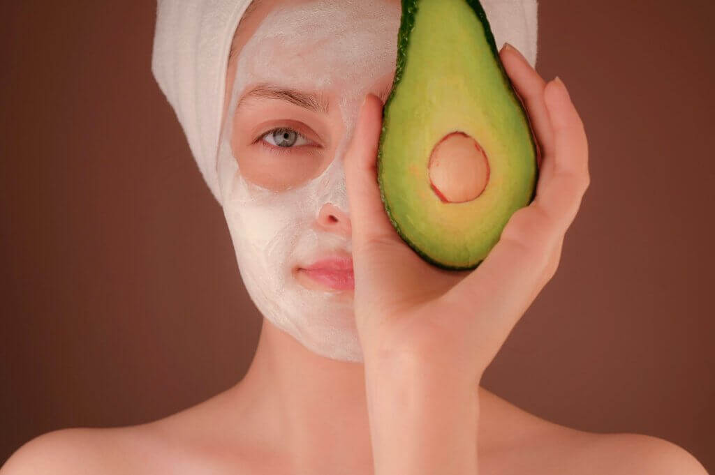 Woman applying a clay face mask.
