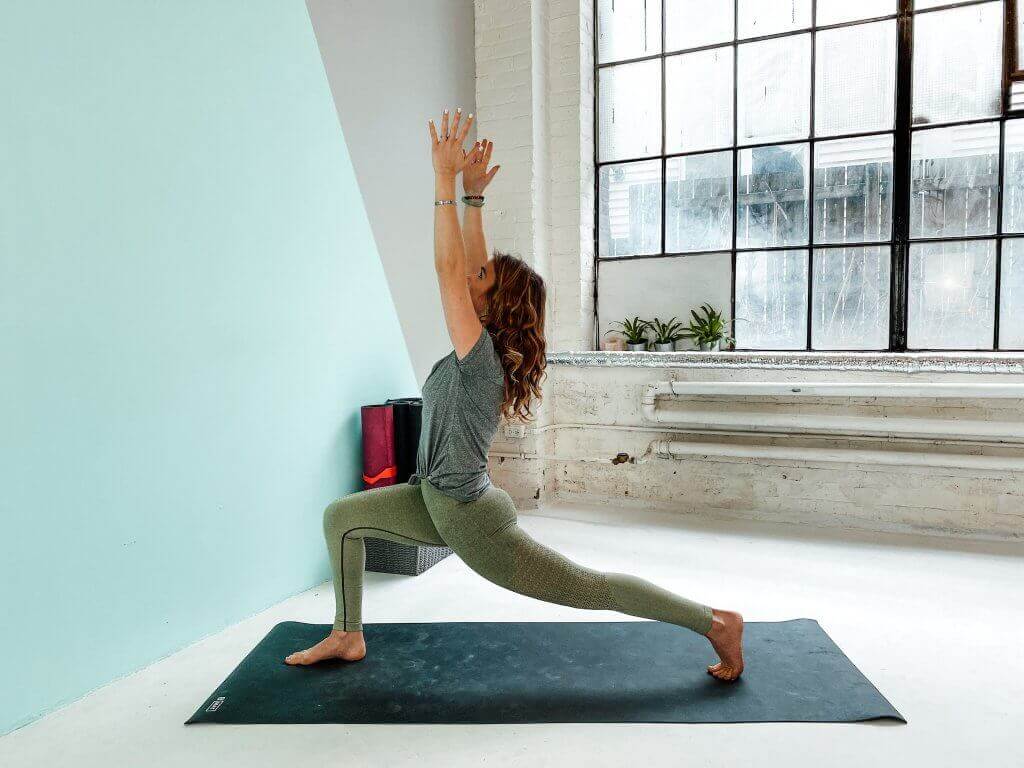 Woman in an energetic Crescent or High Lunge pose.