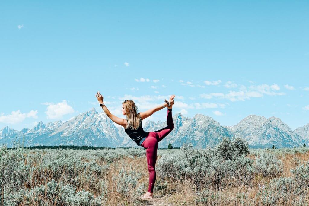 Woman in a graceful Dancer's Pose, demonstrating balance and focus.