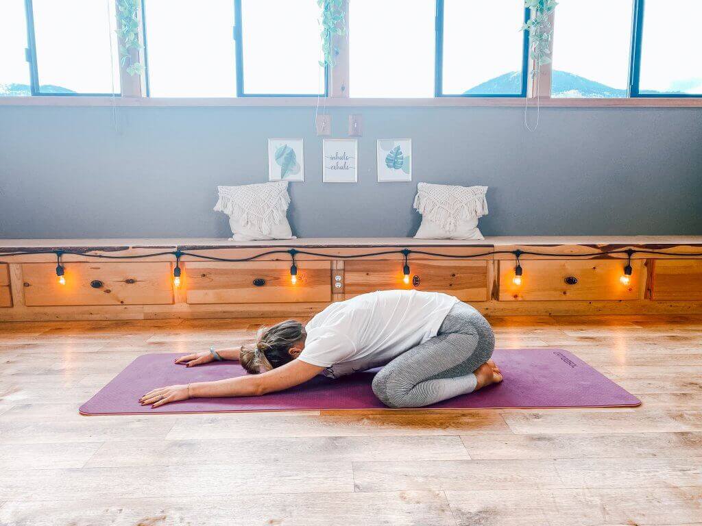 Woman resting in a restorative Child's Pose.