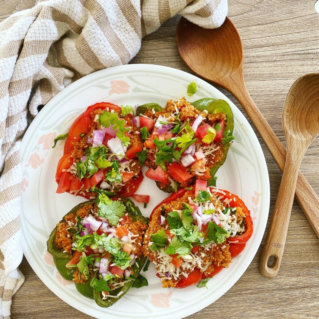 Hearty vegan quinoa stuffed peppers in a baking dish.
