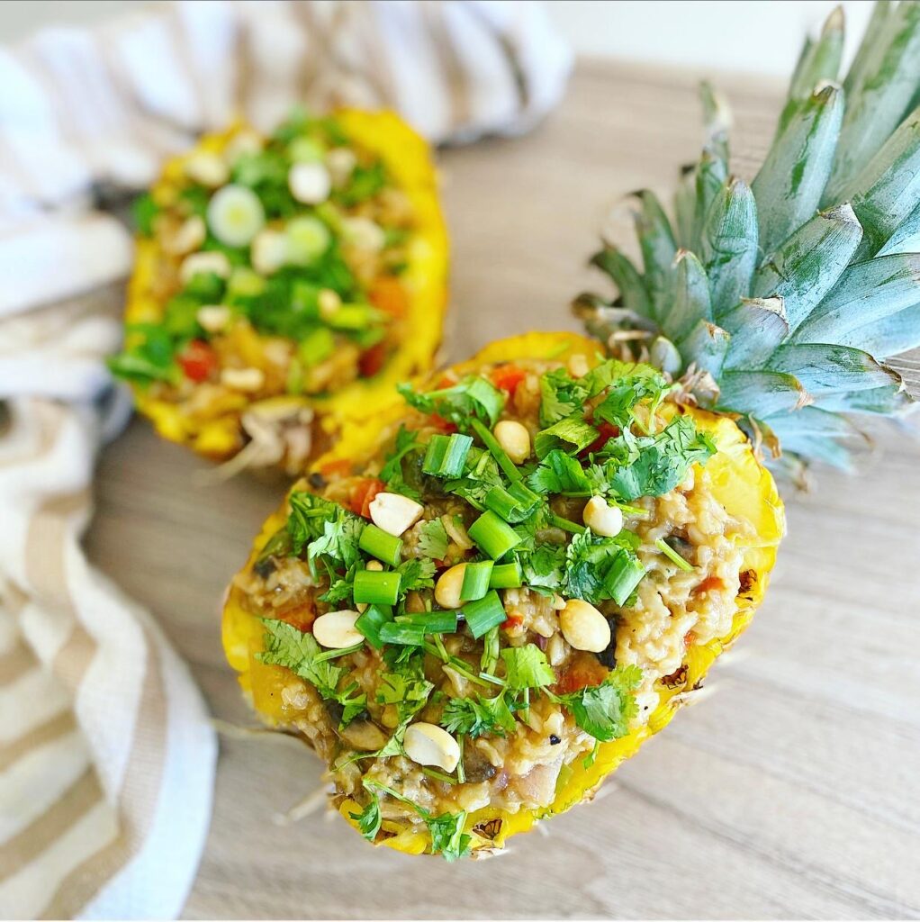 Vegan pineapple fried rice served in a carved-out pineapple bowl.