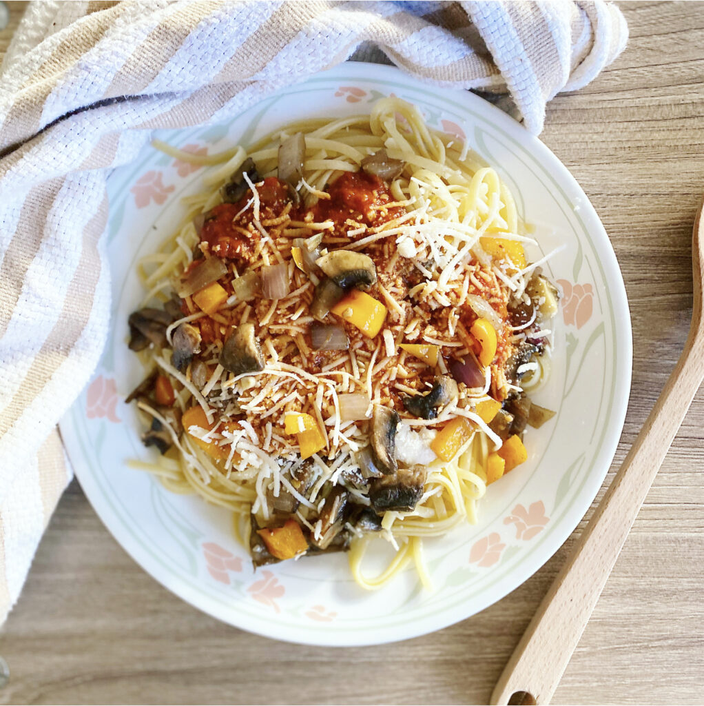 A delicious plate of vegan pasta with a rich tomato sauce and fresh toppings.
